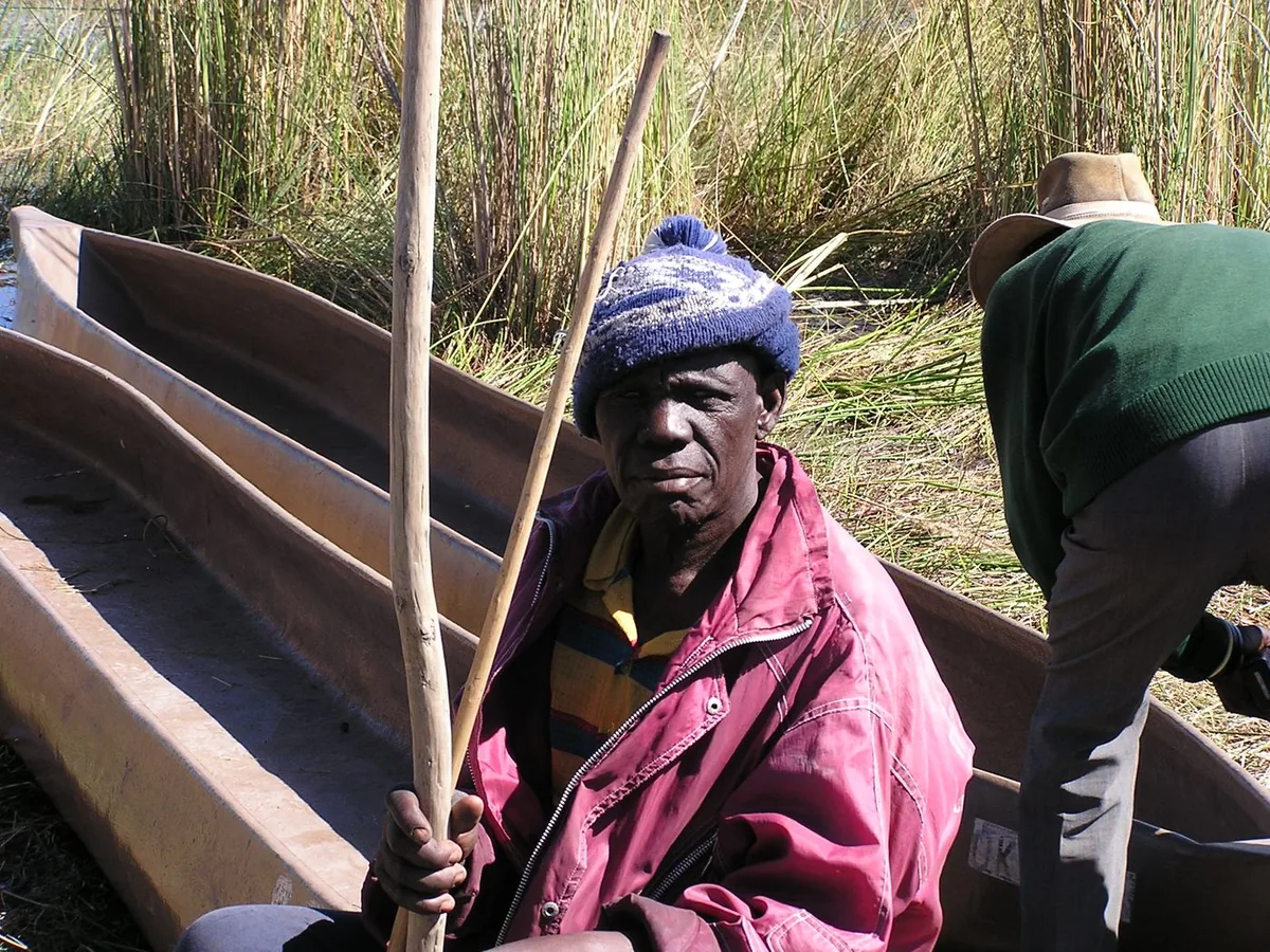 Mokoro polers preparing their dugout canoes in the reeds of the Okavango Delta