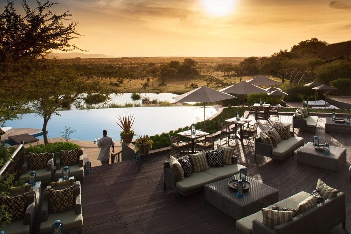 The deck at Four Seasons Safari Lodge Serengeti looking over the waterhole at sunset