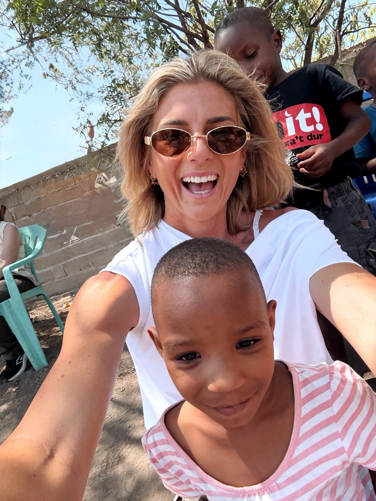 A Kingse Safaris guest meeting a child during a visit to the Karatu community school