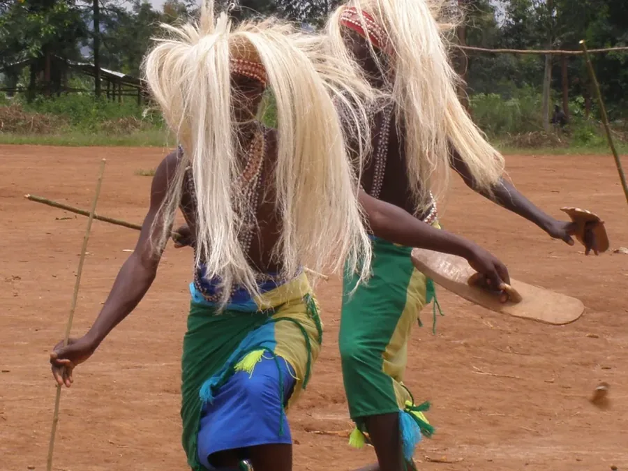 Two Intore dancers in raffia headdresses performing near Kigali