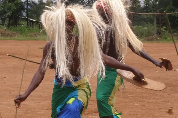 Two Intore dancers in raffia headdresses performing near Kigali
