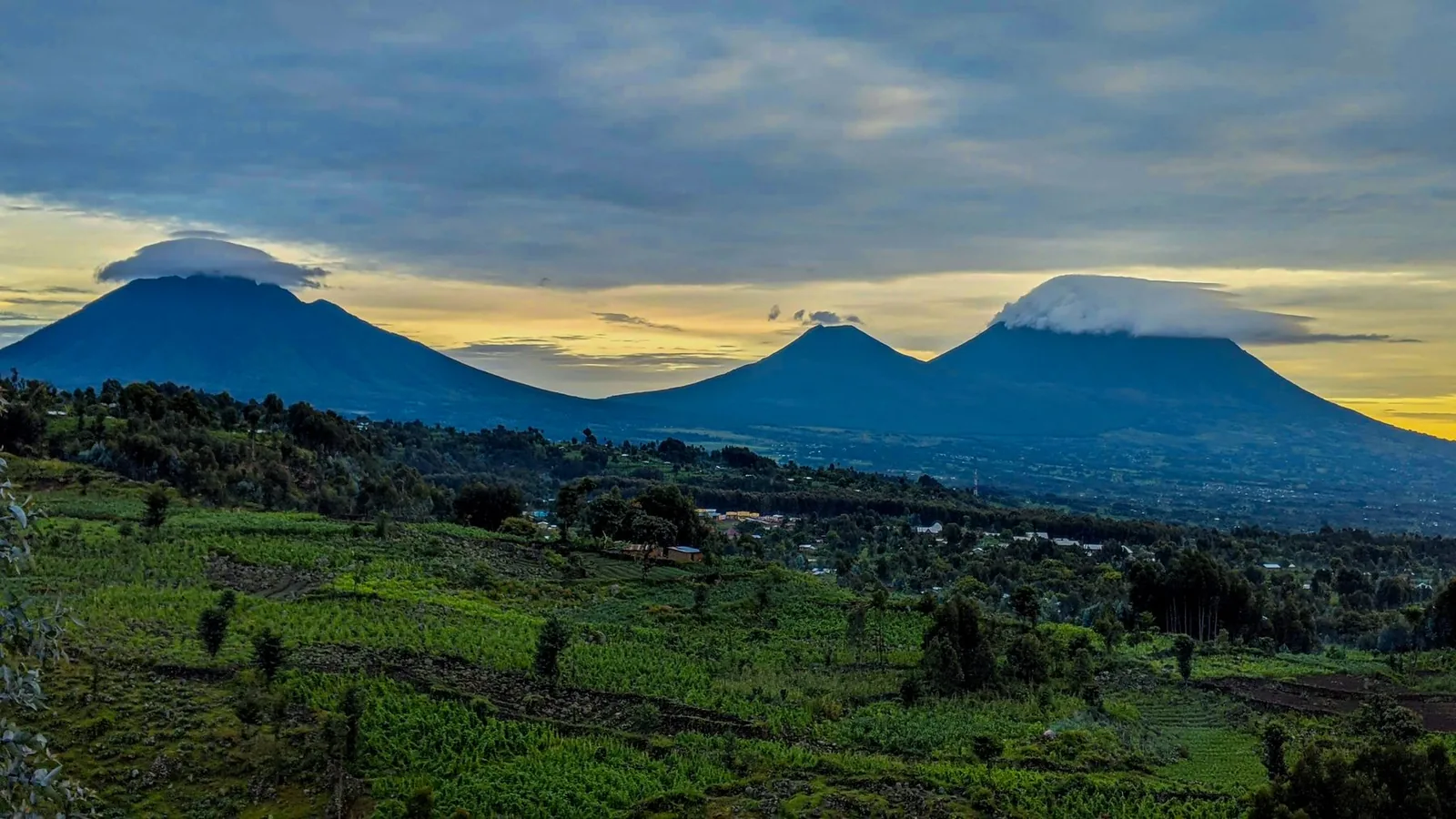 The Virunga volcano chain at dusk above farmland in northern Rwanda