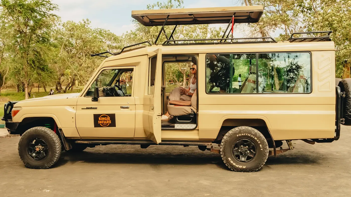 A Kingse Safaris Land Cruiser with its door open, ready for guests
