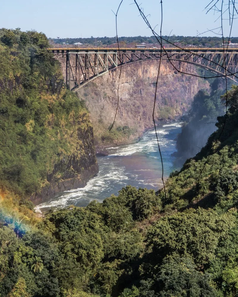 The Victoria Falls Bridge above the Batoka Gorge, with a rainbow in the spray below it
