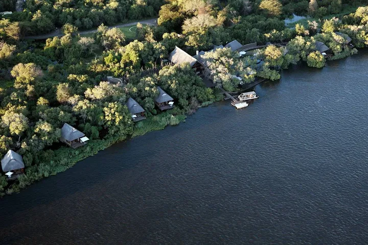 An aerial view of the lodge among trees on a bend of the Zambezi at Royal Chundu