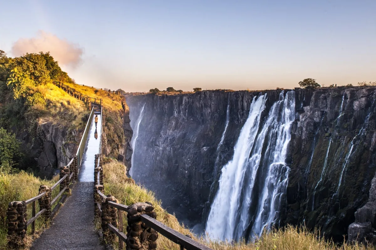 Water pouring over the cliff at Victoria Falls beside the footpath and viewing point